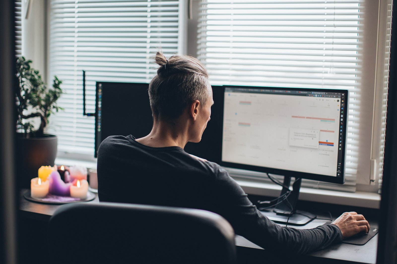 Paid media manager working at dual monitors in a home office